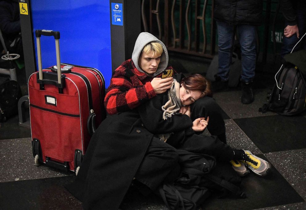 PHOTO: A couple use their phones as they take shelter in a metro station in Kyiv, Ukraine in the morning of February 24, 2022.
