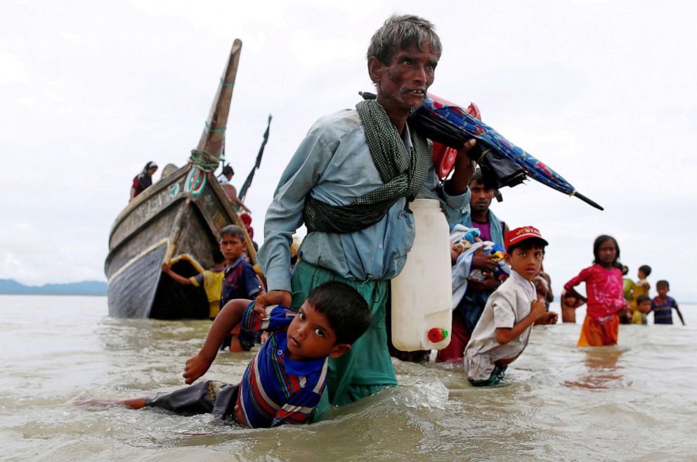 PHOTO: A Rohingya refugee pulls a child to the shore after crossing the Bangladesh-Myanmar border by boat through the Bay of Bengal in Shah Porir Dwip, Bangladesh, Sept. 10, 2017.