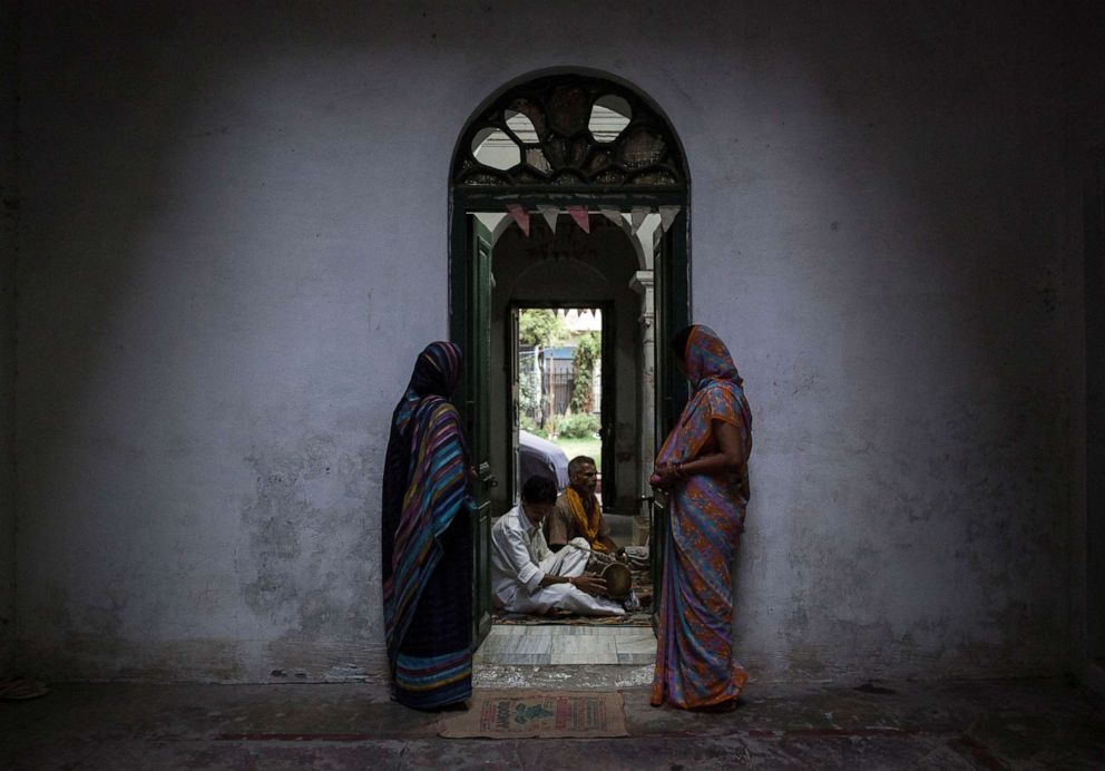 PHOTO: Relatives of patrons listen to priests as they chant during evening prayers at the Mukti Bhavan (Salvation House) in Varanasi, in the northern Indian state of Uttar Pradesh, June 17, 2014.