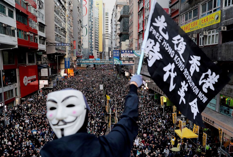 PHOTO: A protester wearing a Guy Fawkes mask waves a flag during a Human Rights Day march, organized by the Civil Human Right Front, in Hong Kong, Dec. 8, 2019.