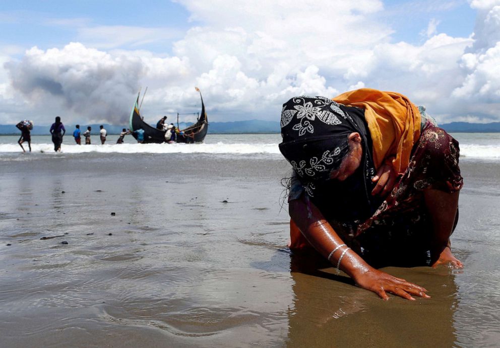 PHOTO: An exhausted Rohingya refugee touches the shore after crossing the Bangladesh-Myanmar border by boat through the Bay of Bengal, in Shah Porir Dwip, Bangladesh Sept. 11, 2017.