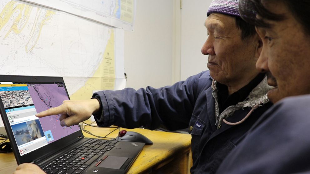 PHOTO: Elder Jimmy Iqaluit and Hunter Johnny Kurluarok review posts on the SIKU online platform as a part of developing the platform.