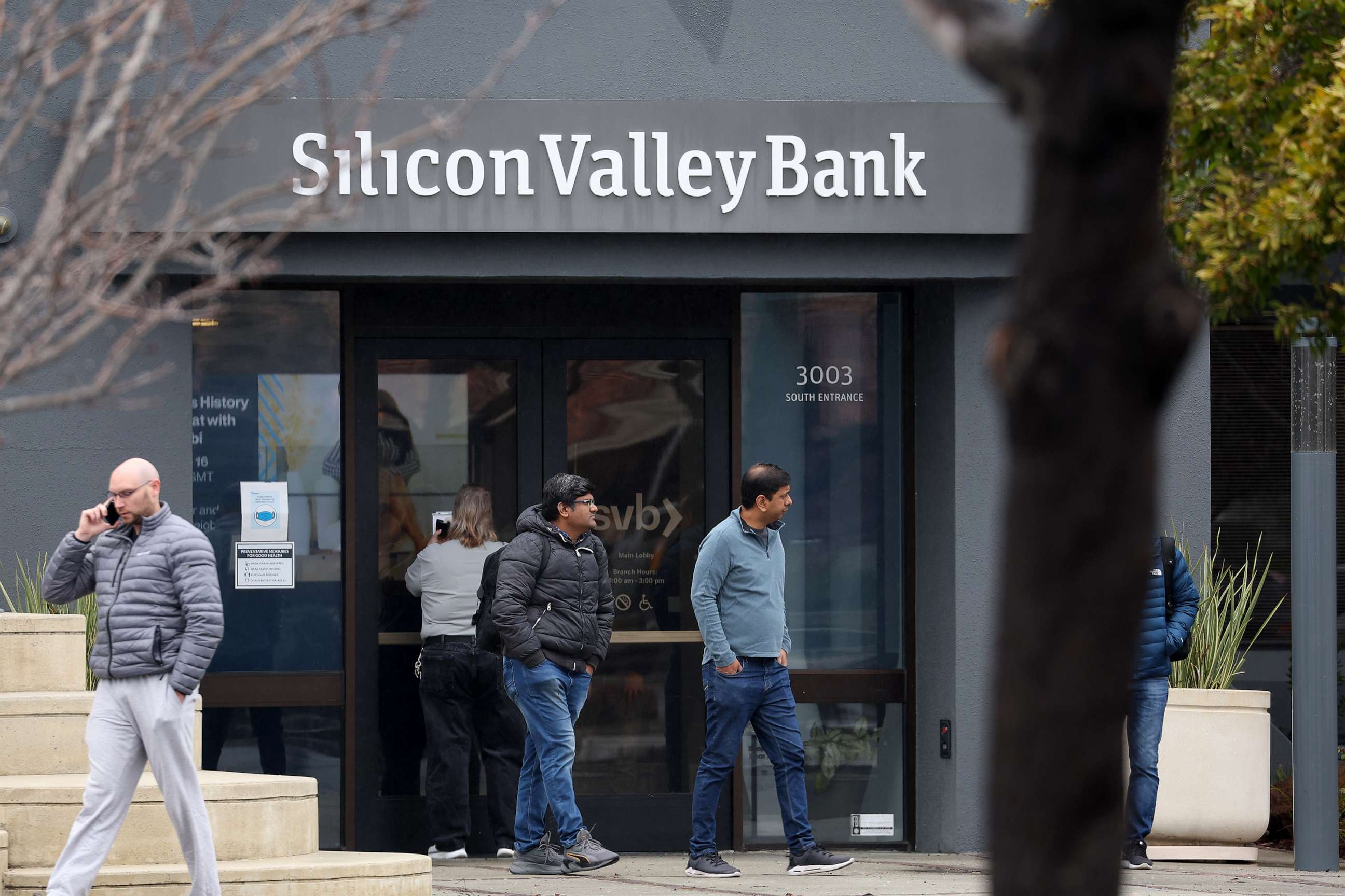 PHOTO: Employees stand outside of the shuttered Silicon Valley Bank (SVB) headquarters on March 10, 2023, in Santa Clara, Calif.