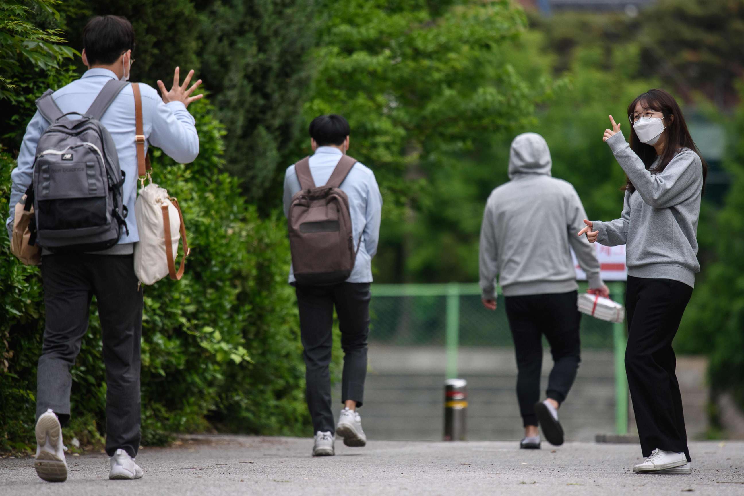 PHOTO: A staff member greets students as they arrive at Kyungbock High School in Seoul on May 20, 2020.