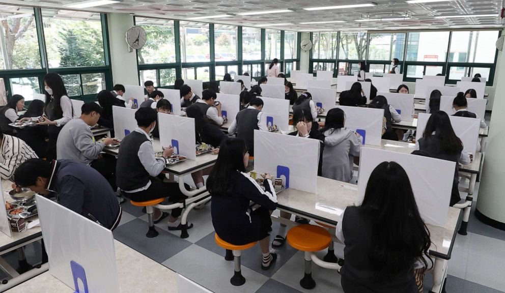 PHOTO: High school students eat a lunch at a school cafeteria which has screens on tables for preventing infections  in Ulsan, South Korea, May 20, 2020.