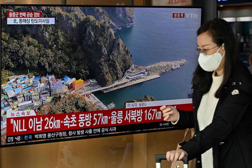 PHOTO: A woman walks past a television screen showing a news broadcast with live footage of the island of Ulleungdo at a railway station in Seoul on Nov. 2, 2022.