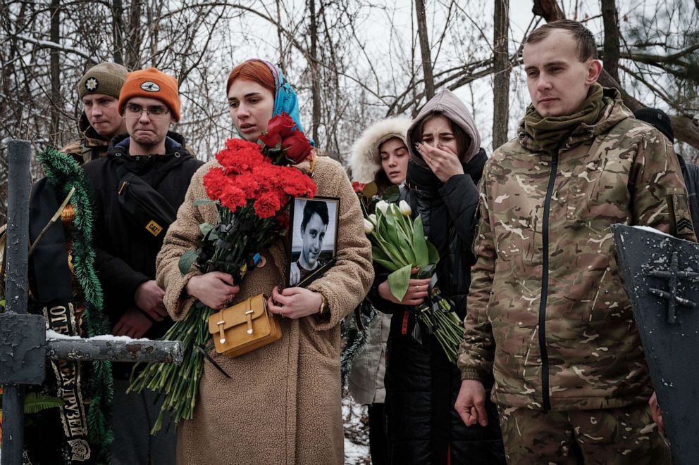 PHOTO: TKateryna Avdeyeva holds a portrait of her late friend, Ukrainian serviceman Oleksandr Korovniy, 28, of the Azov battalion, who was killed in action in Bakhmut, at a cemetery in Sloviansk on Jan. 30, 2023.