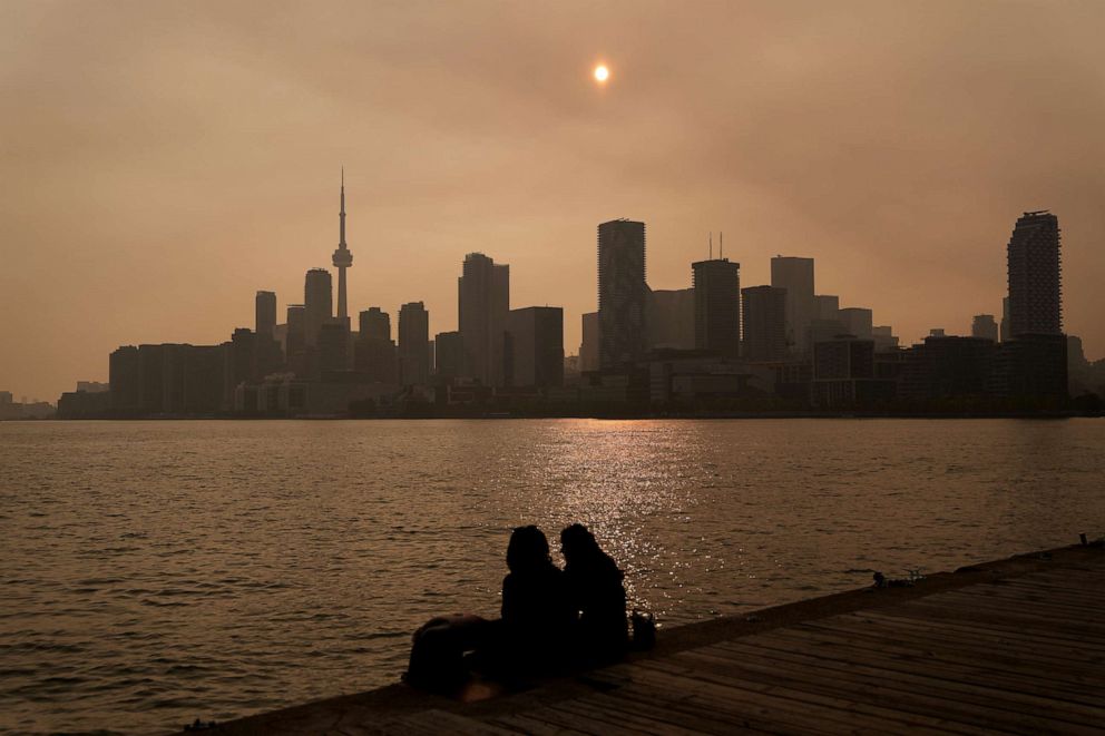 PHOTO: People watch the sunset as smoke from wildfires is visible in Toronto on June 28, 2023.