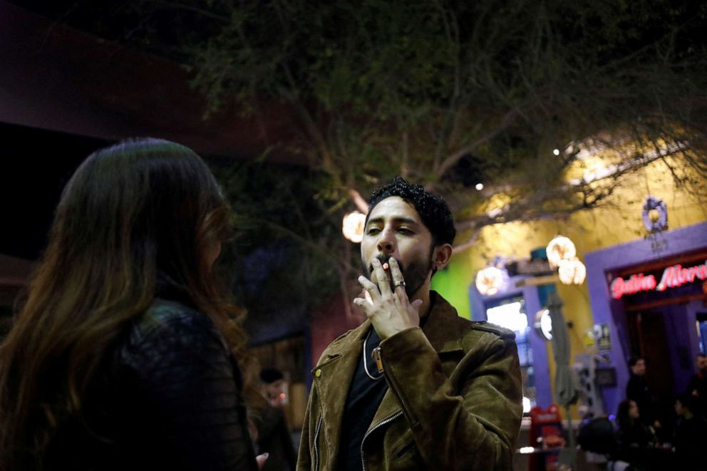 PHOTO: A man smokes a cigarette outside a bar, before smoking was banned in public spaces according to a reform of the Mexican government's regulation of the general law for tobacco control, in Monterrey, Mexico, Jan. 14, 2023.