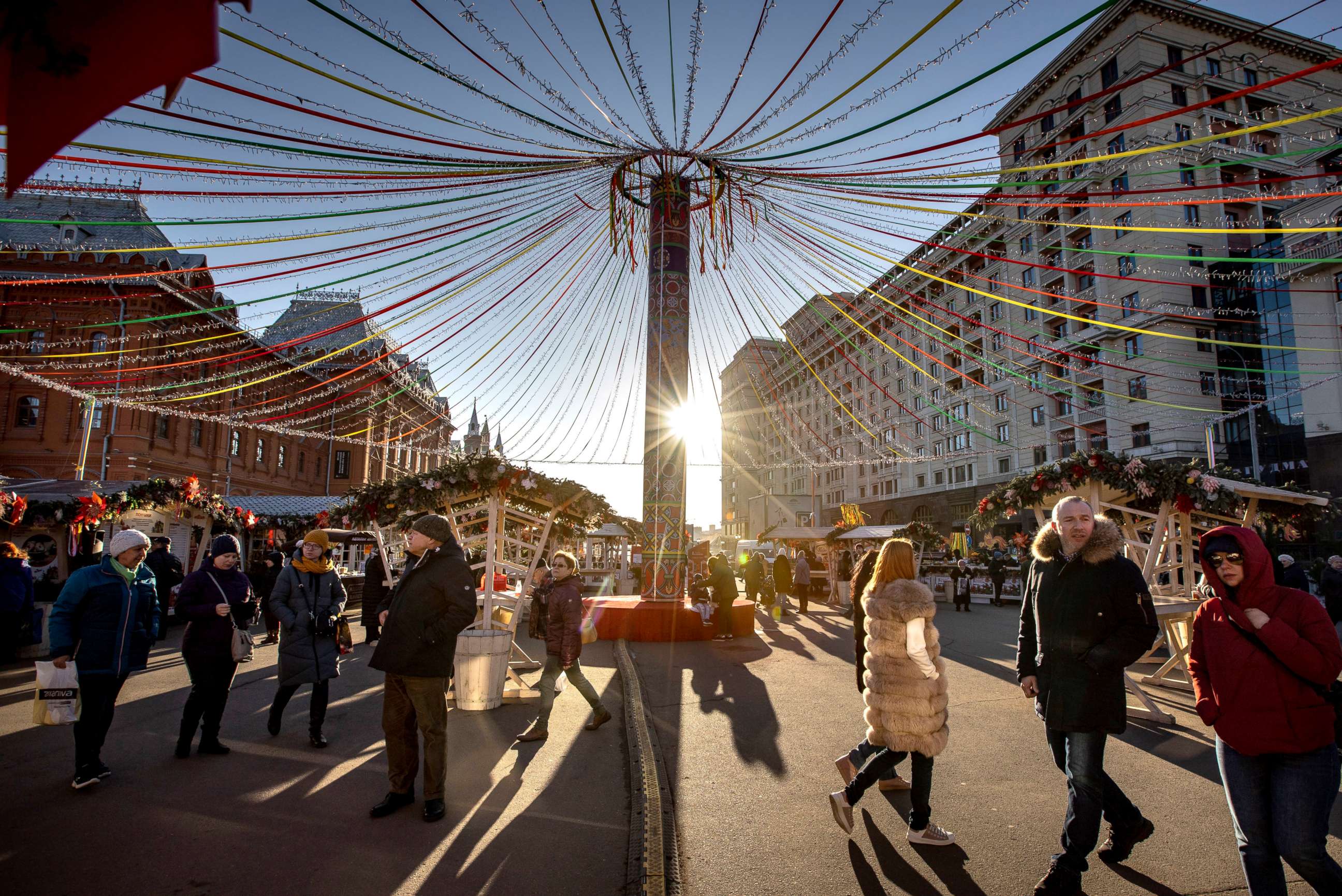 PHOTO: Tourists walk at a holiday market during Maslenitsa (Shrovetide) celebrations in front of the Historical Museum, left, and historical hotel Moscow on Revolution Square near the Kremlin Wall in Moscow, Russia, Feb. 25, 2020.