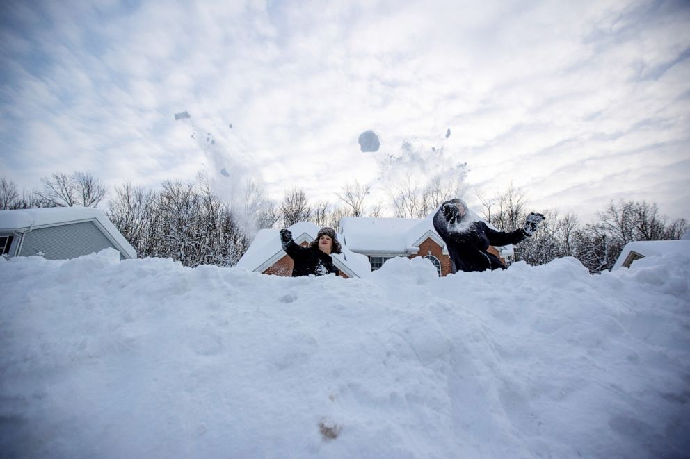 PHOTO: Lincoln Salgado and his pal Cameron Kelly throw a snow ball at their friend across the street during a break in the snow storm hitting the Buffalo area, in Orchard Park, New York, Nov. 19, 2022. 