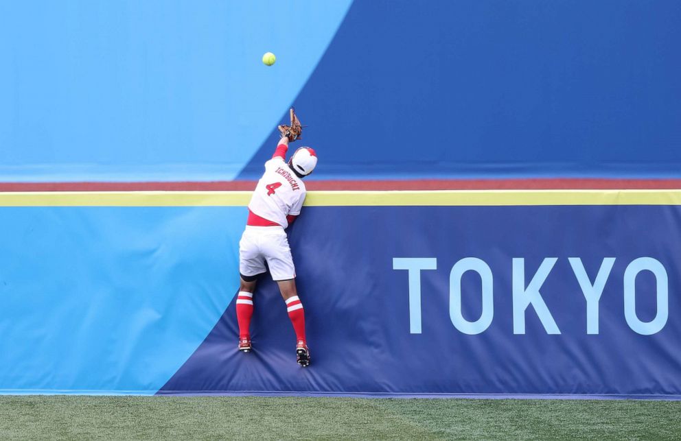 PHOTO: Yuka Ichiguchi #4 of Team Japan reaches but can't catch the ball going over the right field fence hit by Kelsey Stewart #7 of Team United States for a walk-off home run in the eighth inning during softball opening round.