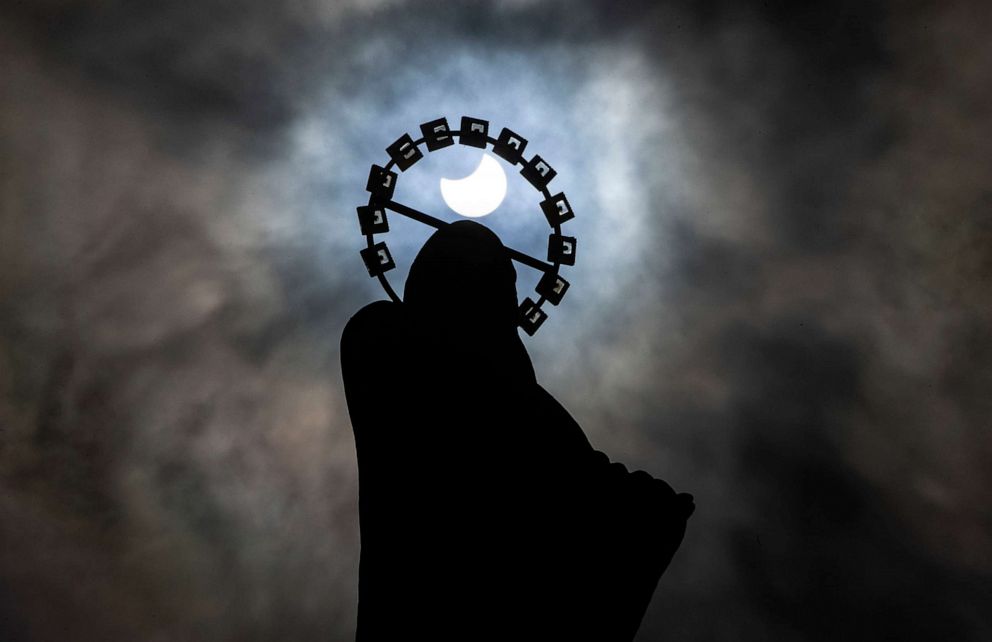 PHOTO: A statue of Our Lady, Star Of The Sea on Bull Wall in Dublin, is silhouetted against the sky during a partial solar eclipse, June 10, 2021.