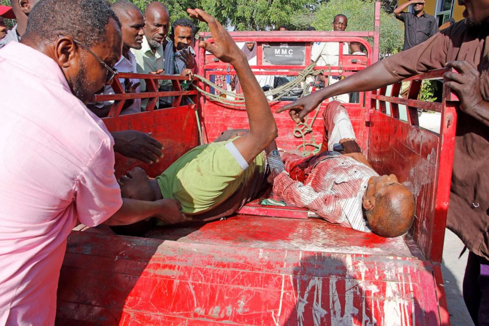 PHOTO: Civilians who were wounded in suicide car bomb attack are helped at check point in Mogadishu, Somalia, Saturday, Dec, 28, 2019. 