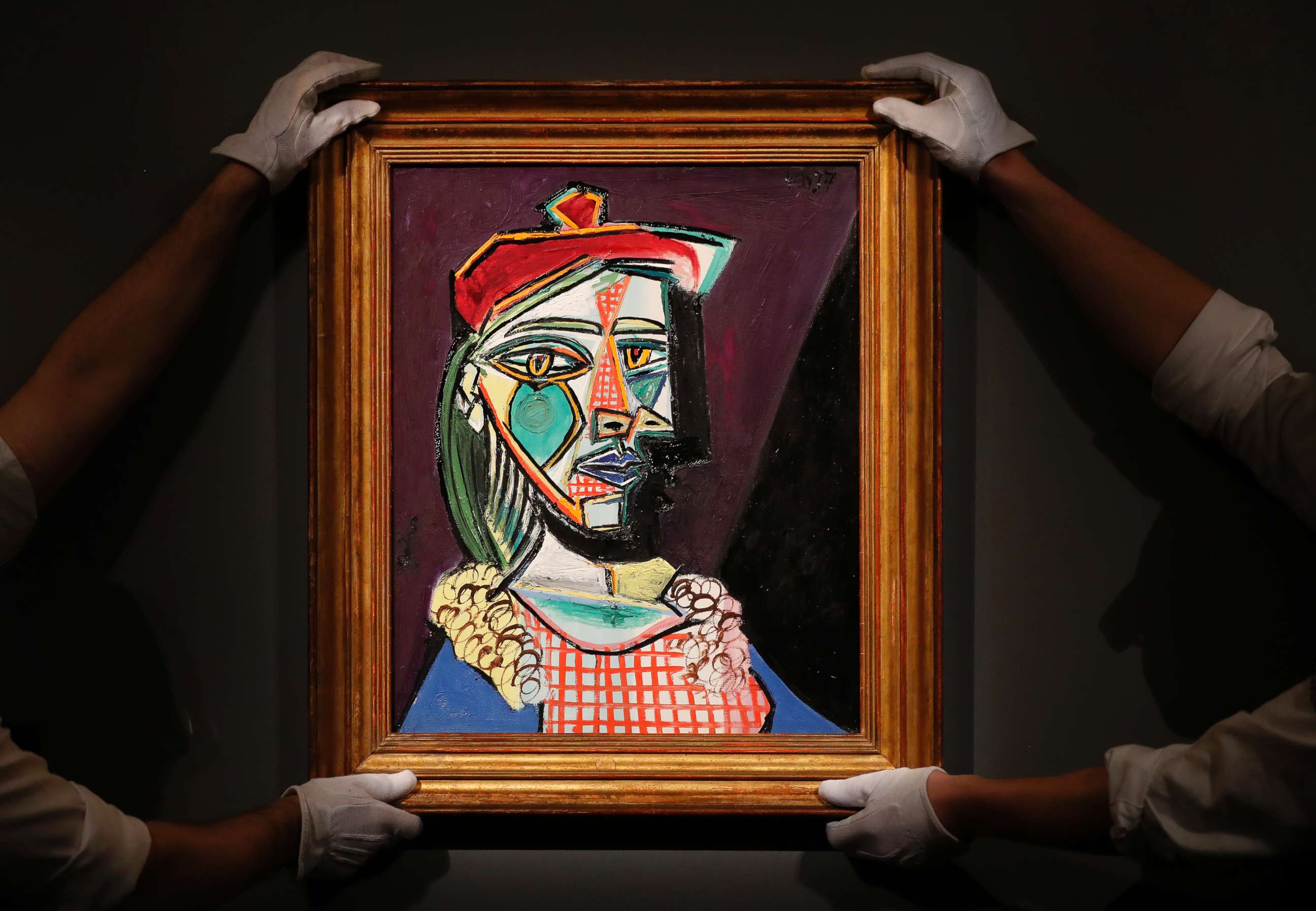 PHOTO: Sotheby's employees hold up Pablo Picasso 1937 "Femme au beret et a la robe quadrillee," at Sotheby's auction house in London, Feb. 22, 2018.