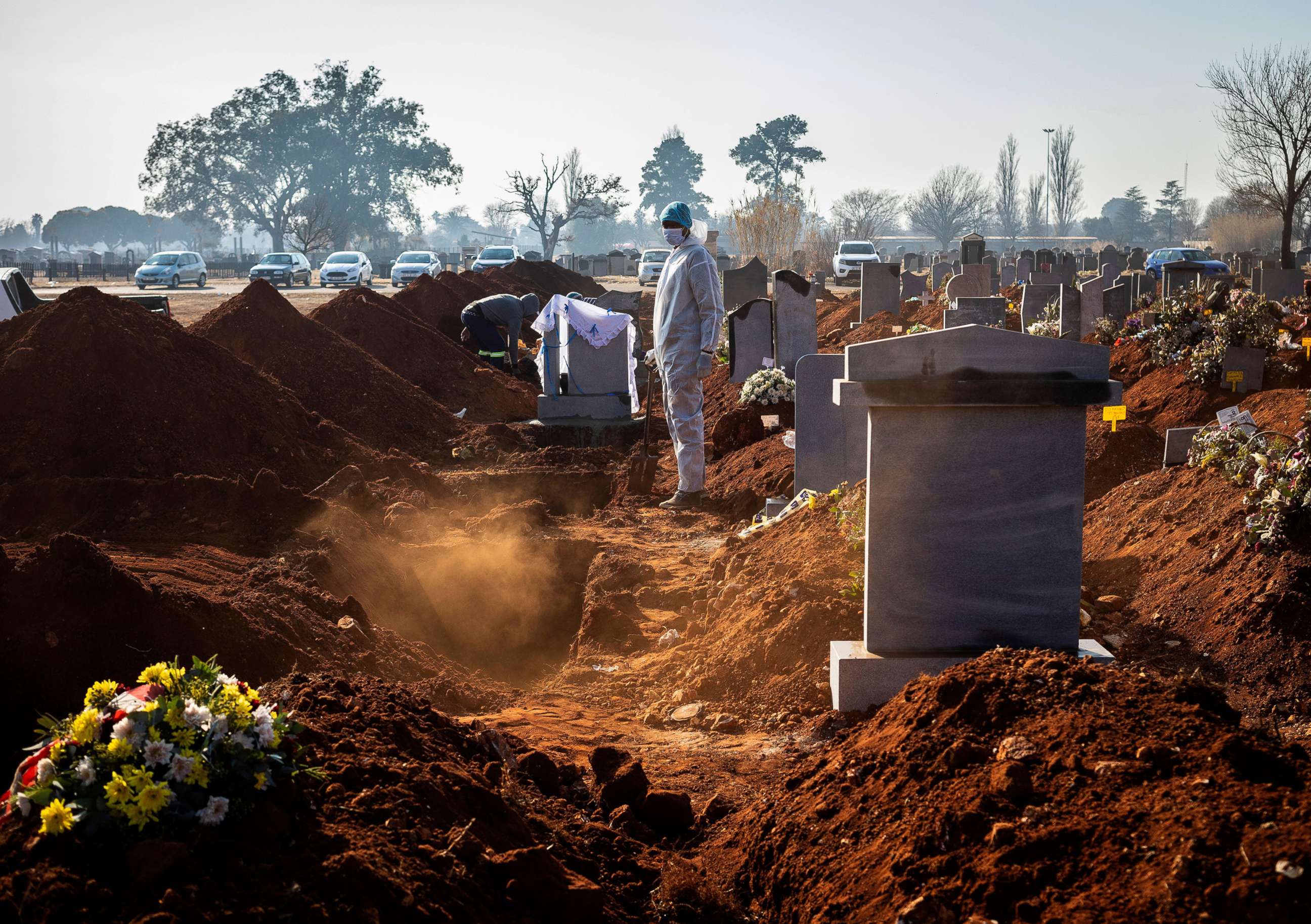 PHOTO: A family member wearing PPE looks on after the funeral of family member who died from Covid-19 at a graveyard on the 119 day of the pandemic lockdown in Johannesburg, July 24, 2020.