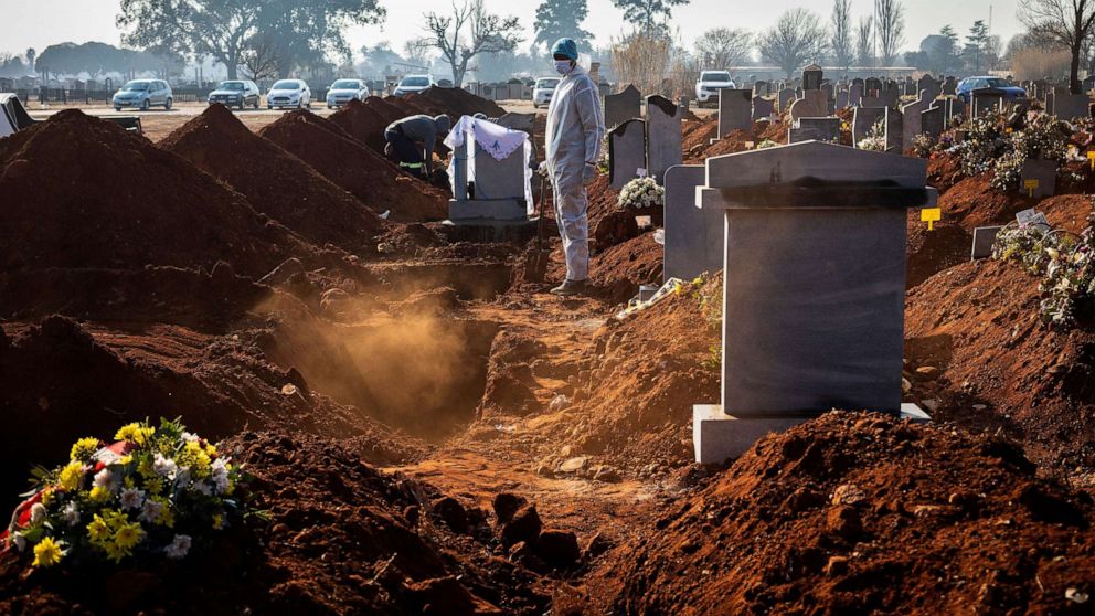 PHOTO: A family member wearing PPE looks on after the funeral of family member who died from Covid-19 at a graveyard on the 119 day of the pandemic lockdown in Johannesburg, July 24, 2020.