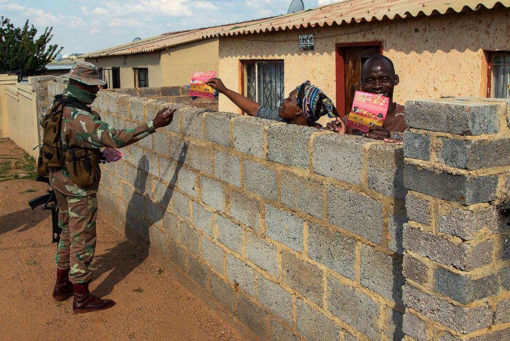 PHOTO: A soldier hands out flyers about the novel coronavirus to a resident on the streets of Soweto, South Africa, April 23, 2020, as the country remains in lockdown for a fourth week in a bid to combat the spread of the coronavirus.