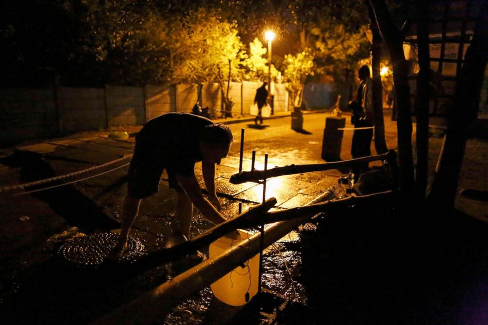 PHOTO: Residents of Cape Town collect water before sunrise to avoid long queues at a mountain river water collection point in Cape Town, South Africa, March 14, 2018.