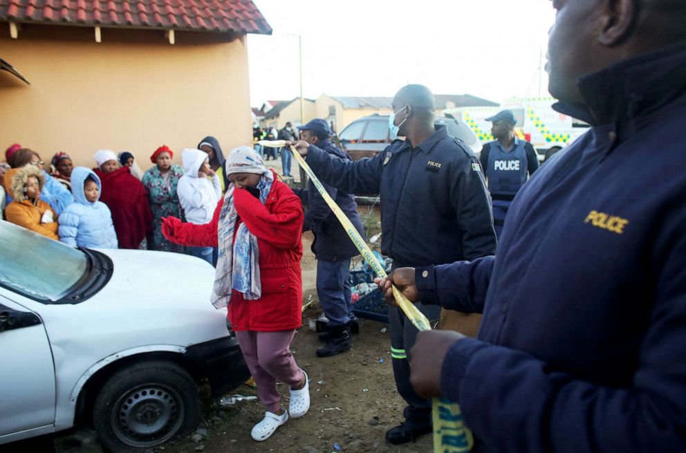 PHOTO: Members of the community and family wait for news outside a township pub where multiple young patrons died in South Africa's southern city of East London, June 26, 2022.