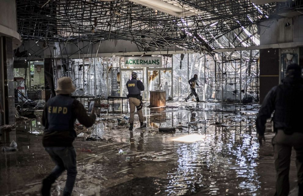 PHOTO: An alleged suspected looter is fired upon with rubber bullets by Ekurhuleni Metro Police Department officers (EMPD) on patrol inside a flooded mall in Vosloorus, on July 13, 2021.