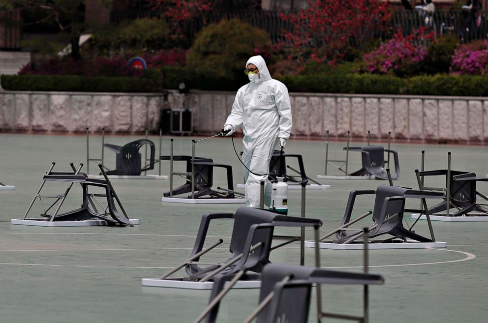 PHOTO: A worker wearing protective gears sprays disinfectant at desks and chairs before an insurance planner qualification exam in Seoul, South Korea, April 25, 2020.