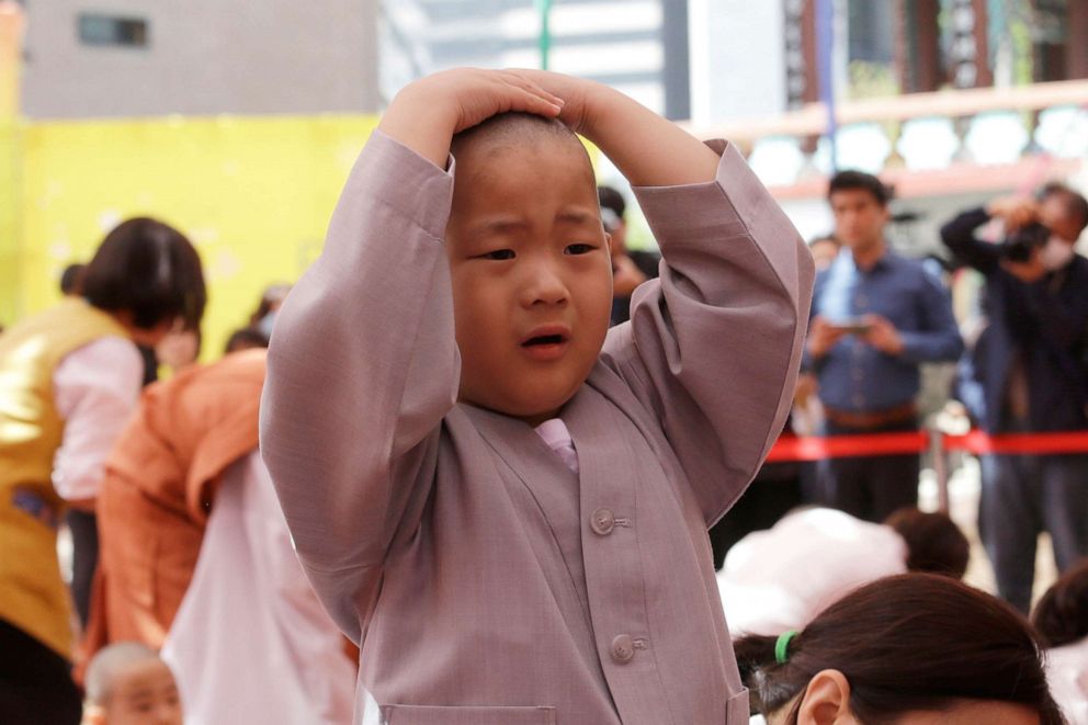 PHOTO: A boy whose Buddhist name is Myung Bub touches his newly shaved head during a service to celebrate Buddha's upcoming 2,563th birthday on May 12, at the Jogye Temple in Seoul, South Korea, April 22, 2019.