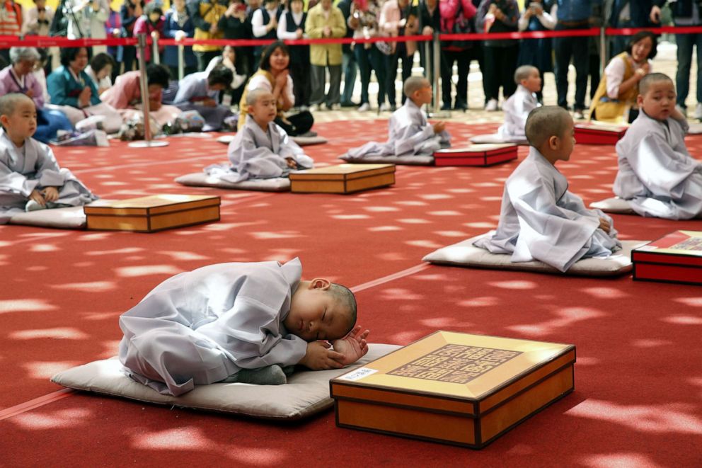 PHOTO: A boy sits on the ground after having his head shaved during the "Children becoming Buddhist monks' ceremony at the Jogyesa temple in Seoul, South Korea, April 22, 2019.