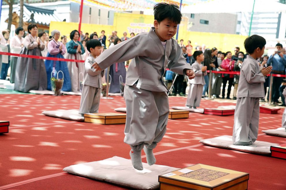 PHOTO:A boy jumps on cushion before having his head shaved during the"Children becoming Buddhist monks" ceremony at the Jogyesa temple in Seoul, South Korea, April 22,  2019.