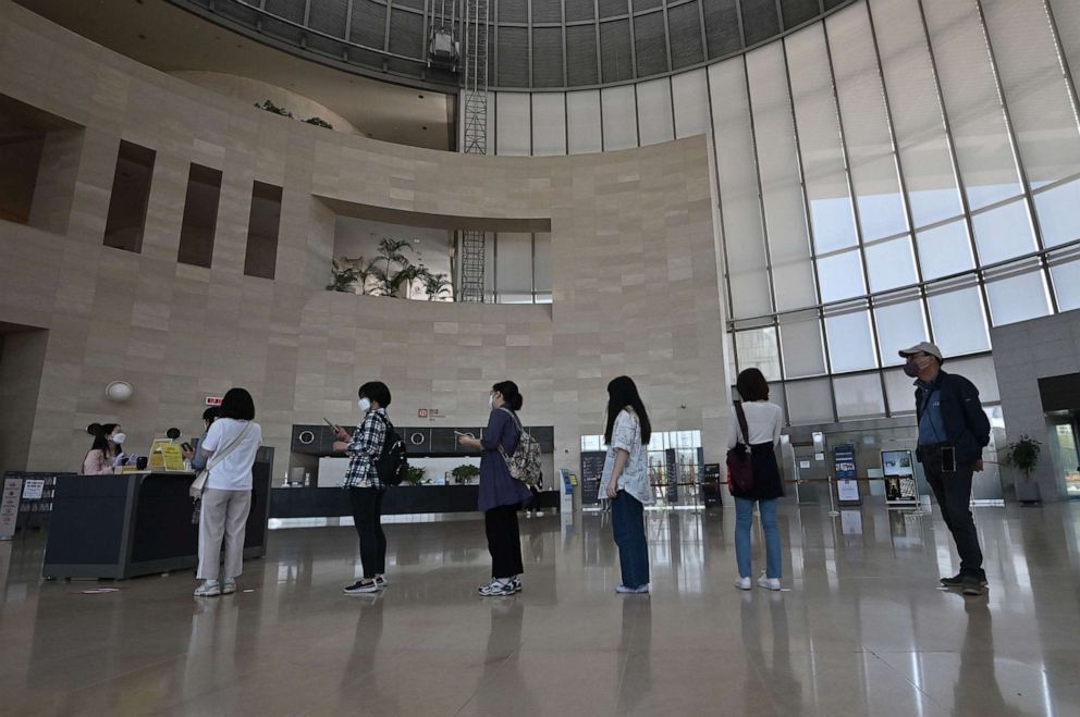 PHOTO: Visitors wearing face masks wait in line to enter an exhibition hall at the National Museum of Korea in Seoul on May 6, 2020.