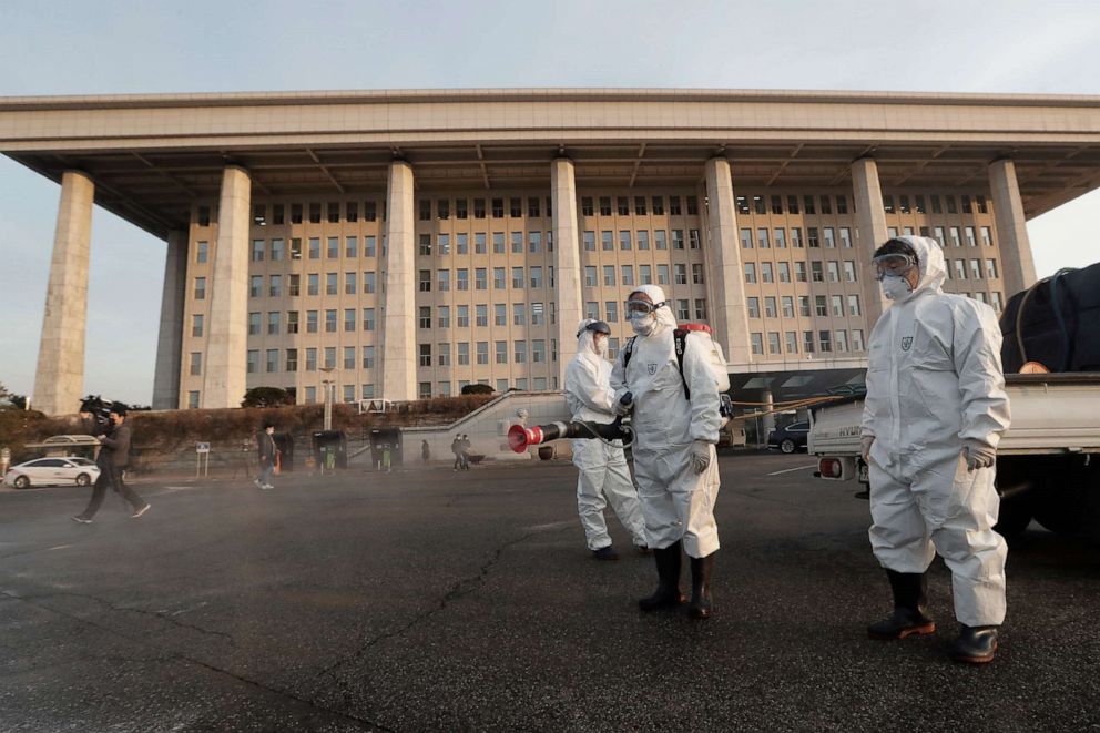 PHOTO: Workers wearing protective suits spray disinfectant as a precaution against the novel coronavirus at the National Assembly in Seoul, South Korea, Feb. 24, 2020.