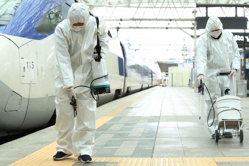 Railway workers wearing protective gear spray disinfectant, as part of preventive measures against the spread of the novel coronavirus, at a railway station in Seoul, South Korea, on February 25, 2020. The novel coronavirus outbreak in South Korea is 'very grave', President Moon Jae-in said on Feb. 25 as he visited its epicenter and the country's total number of cases approached 1,000.-/YONHAP/AFP via Getty Images