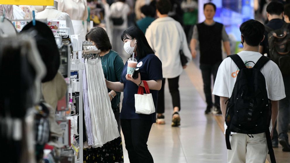 PHOTO: People wearing face masks walk through an underground shopping area in Seoul on May 6, 2020.