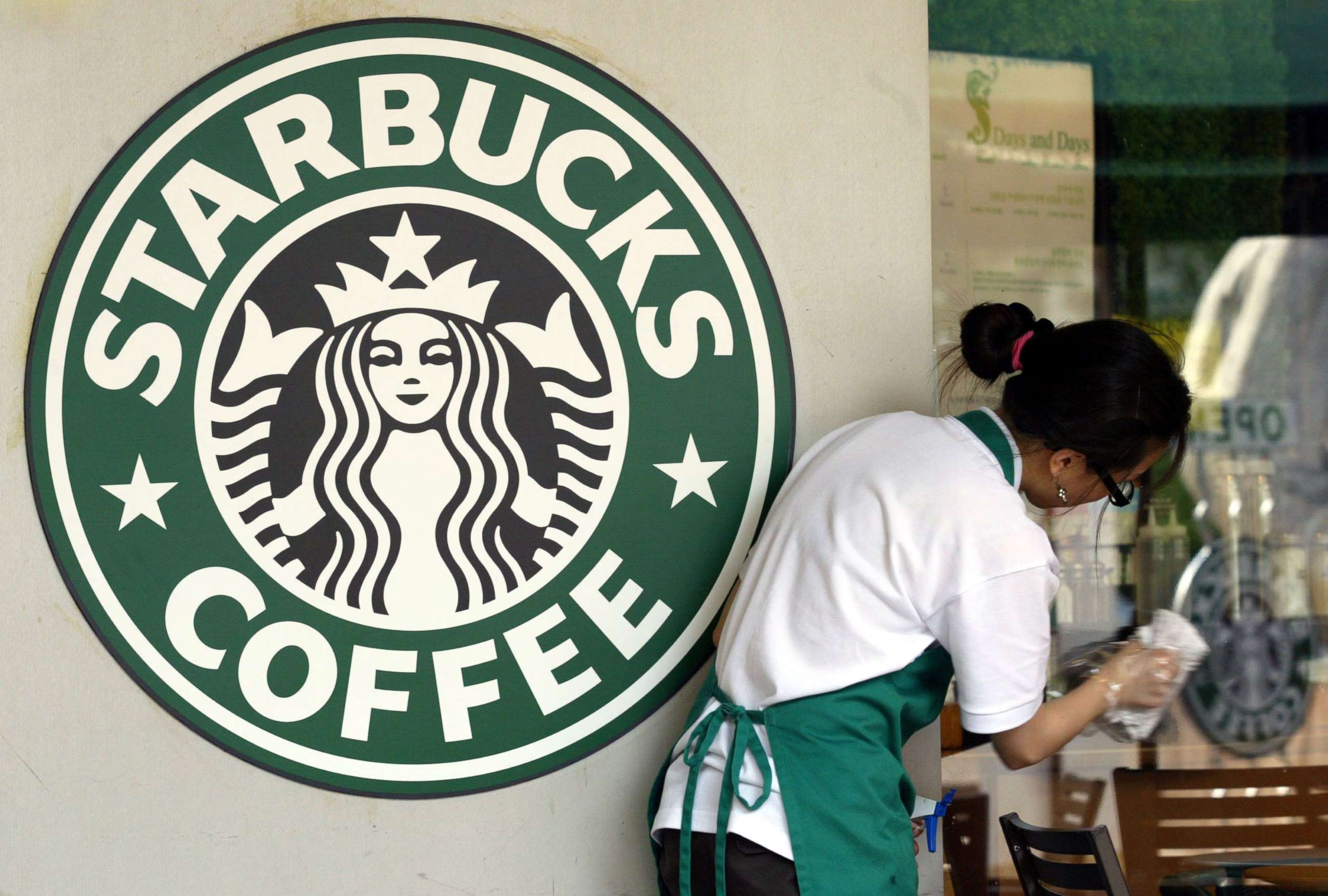 PHOTO: A Starbucks worker cleans the window next to a company logo at a coffee store, May 31, 2006, in Seoul, South Korea.
