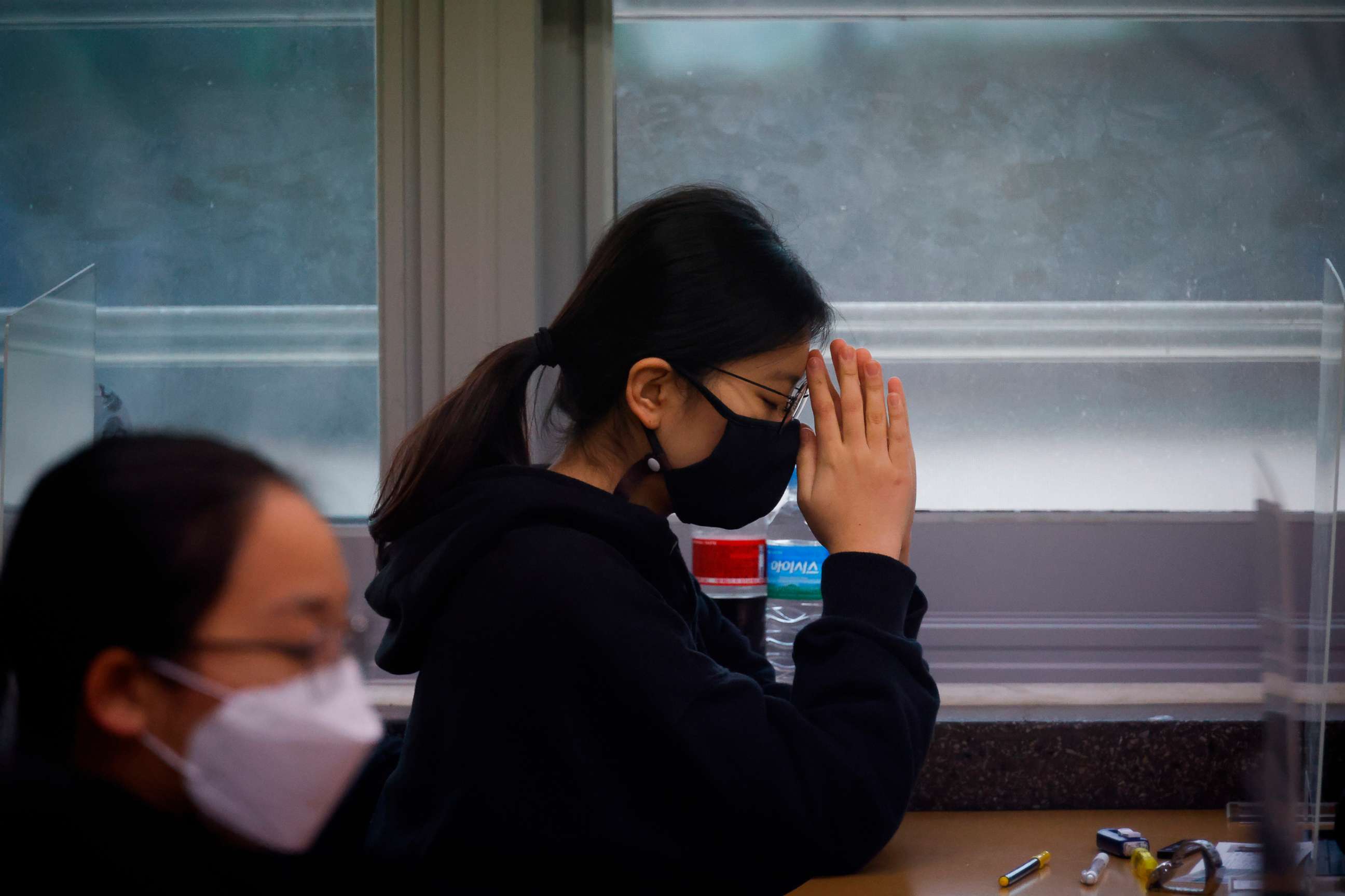 PHOTO: A student  wearing a face mask prays before the start of the annual college entrance examination amid the coronavirus pandemic at an exam hall in Seoul, South Korea, Dec. 3, 2020.