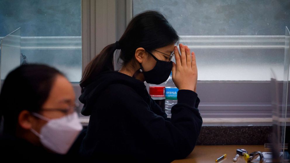 PHOTO: A student  wearing a face mask prays before the start of the annual college entrance examination amid the coronavirus pandemic at an exam hall in Seoul, South Korea, Dec. 3, 2020.