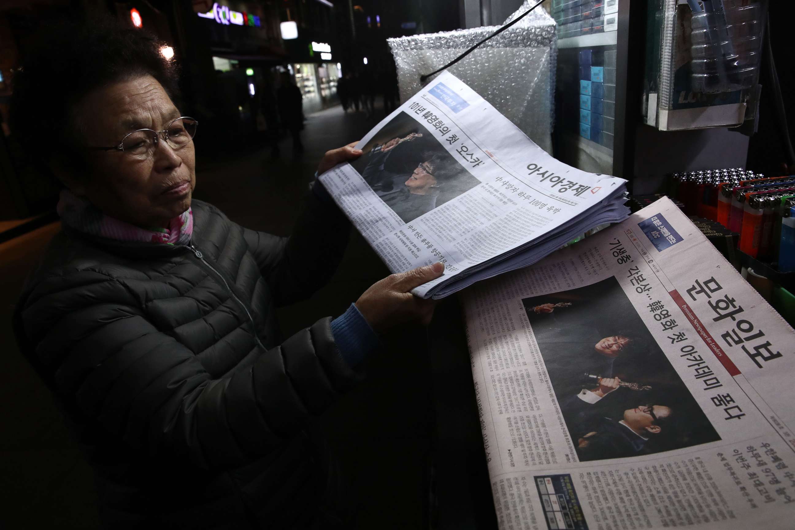 PHOTO: A newsstand vender collects newspapers reporting the South Korean director Bong Joon-ho on February 10, 2020 in Seoul, South Korea. Bong Joon-ho's "Parasite" became the first non-English language film to win best picture. 