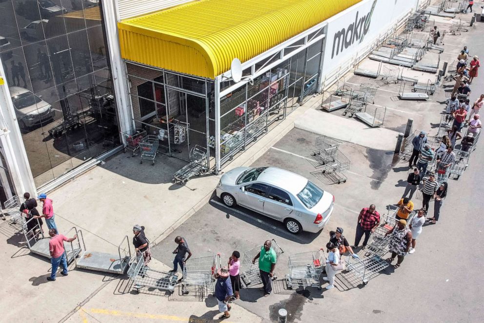 PHOTO: Customers stand in a queue outside a supermarket in Soweto, Johannesburg, South Africa,  March 24, 2020.