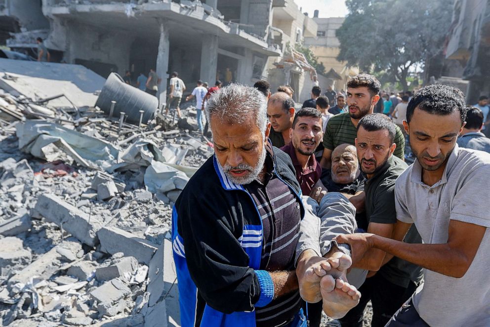 PHOTO: Palestinians carry a wounded man following Israeli strikes on houses in Rafah in the southern Gaza Strip, Oct. 17, 2023.