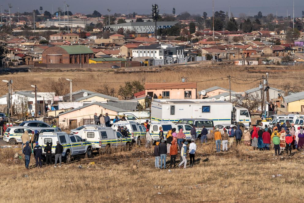 PHOTO: People gather at the scene of an overnight bar shooting in Soweto, South Africa, on July 10, 2022.