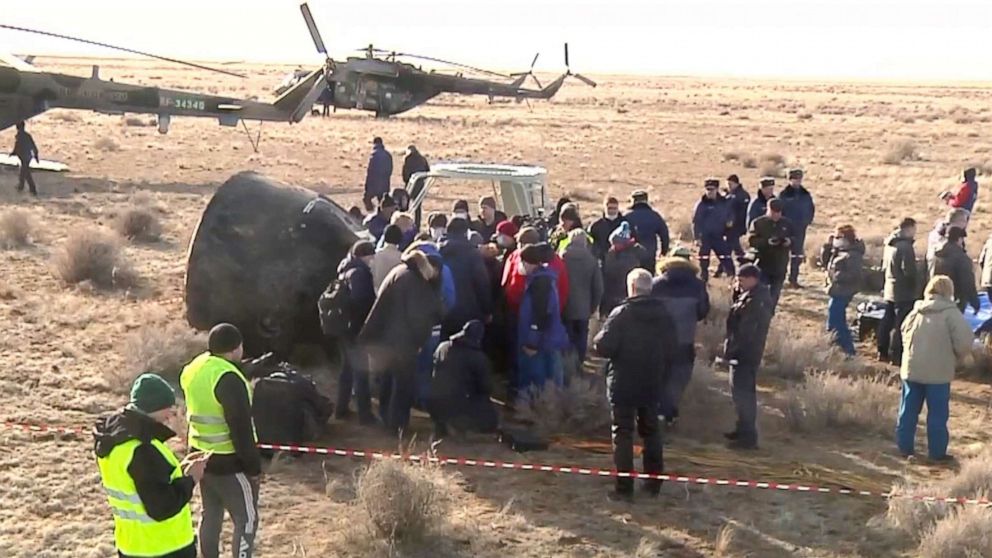 PHOTO: Roscosmos Space Agency, rescue team members stand around the Russian Soyuz MS-19 space capsule shortly after the landing southeast of the Kazakh town of Zhezkazgan, Kazakhstan, March 30, 2022.