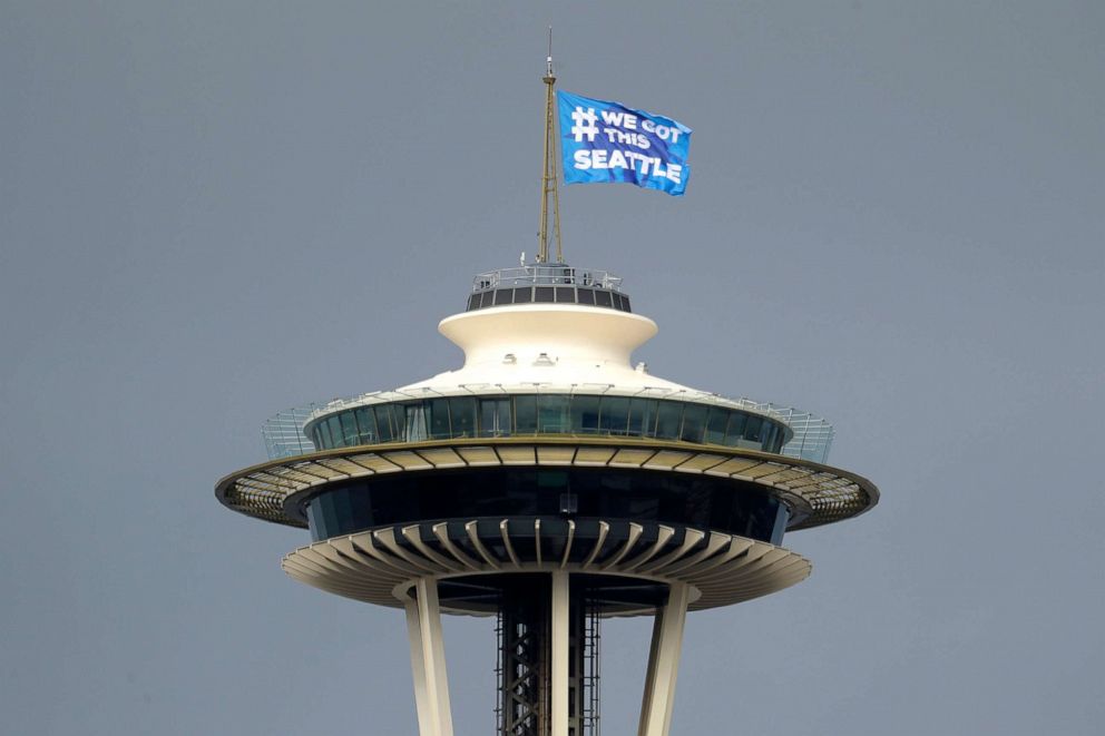 PHOTO: A flag that reads "#We Got This Seattle" flies on the roof of the Space Needle, March 26, 2020, in Seattle.