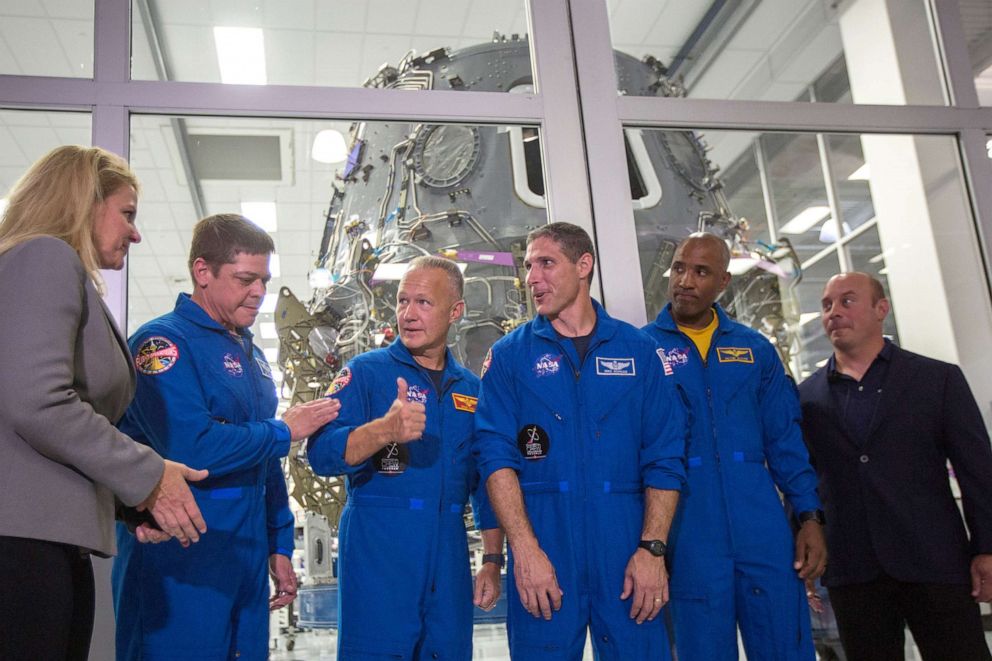 PHOTO: SpaceX President and COO Gwynne Shotwell, NASA Astronauts Bob Behnken, Doug Hurley, Mike Hopkins and Victor Glover, and Director of Crew Mission Management Benji Reed talk in front of the Crew Dragon spacecraft in Hawthorne, Calif., Aug. 13, 2018.