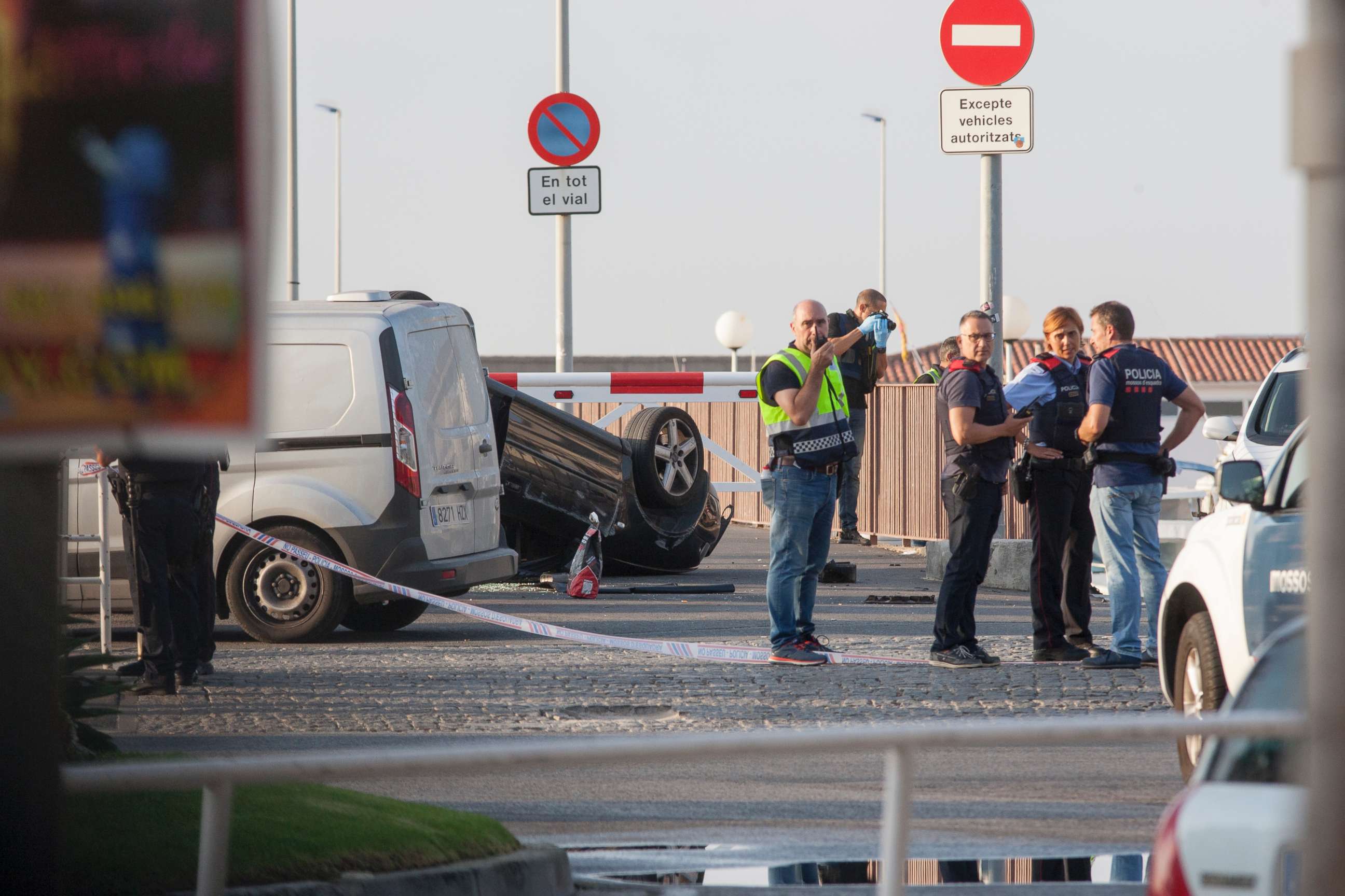 PHOTO: Police officers speaking next to a rolled over car at the location where police shot dead five terrorists in Cambrils, Spain, Aug. 18, 2017. 