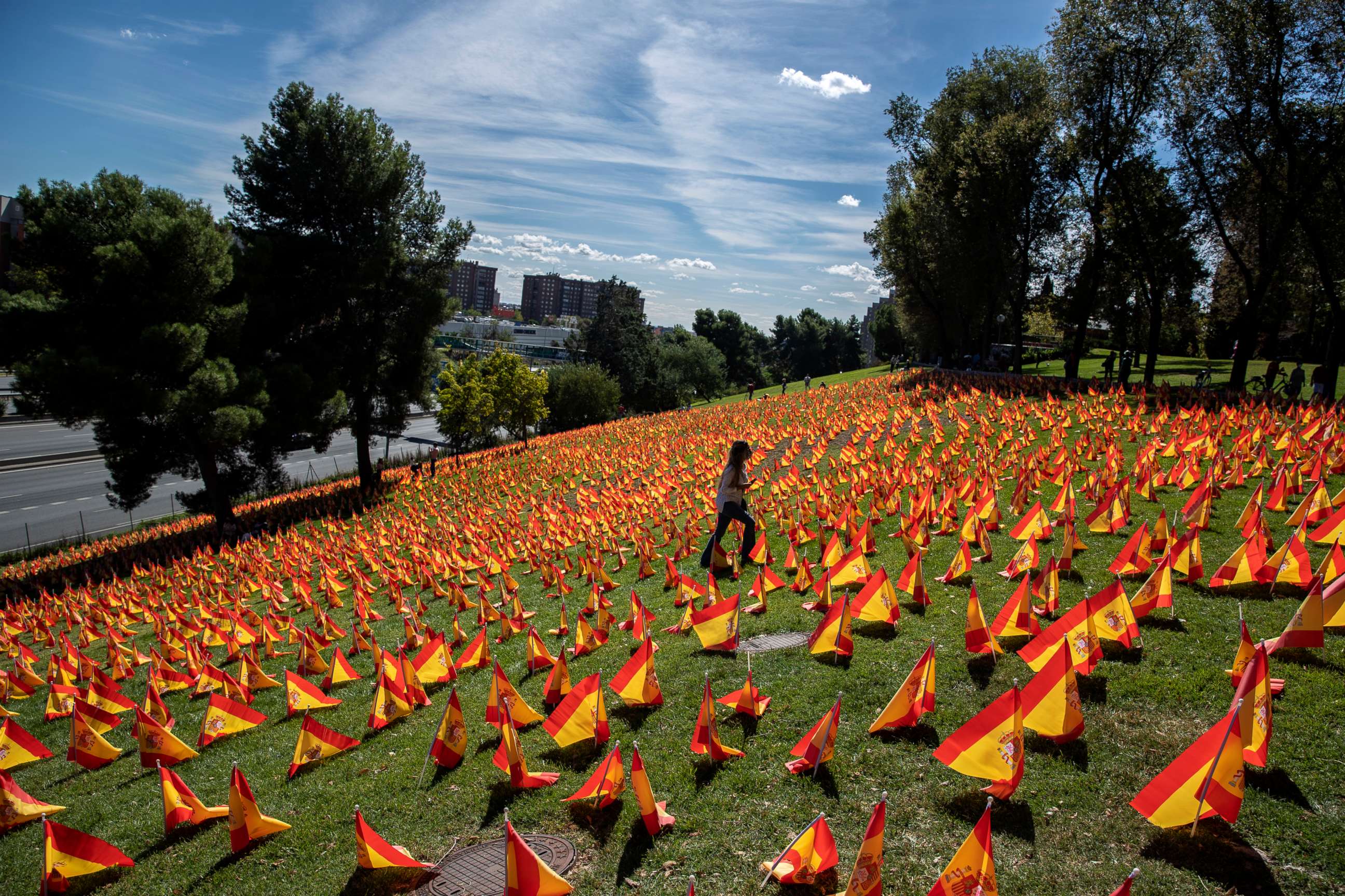 PHOTO: A woman walks among the Spanish flags placed in memory of COVID-19 victims in Madrid Sept. 27, 2020. Spain has become the first western Europe to accumulate more than 1 million confirmed infections.