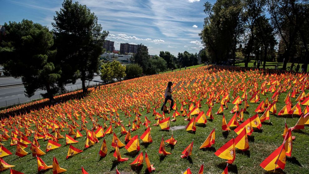 PHOTO: A woman walks among the Spanish flags placed in memory of COVID-19 victims in Madrid Sept. 27, 2020. Spain has become the first western Europe to accumulate more than 1 million confirmed infections.