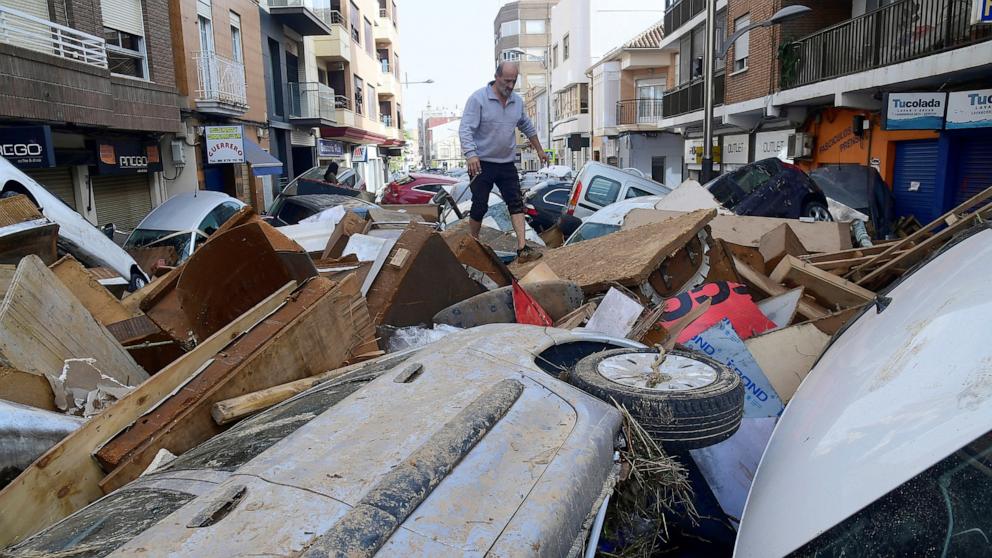 PHOTO: A man climbs on piled up cars following deadly floods in Sedavi, south of Valencia, eastern Spain, on Oct. 30, 2024.