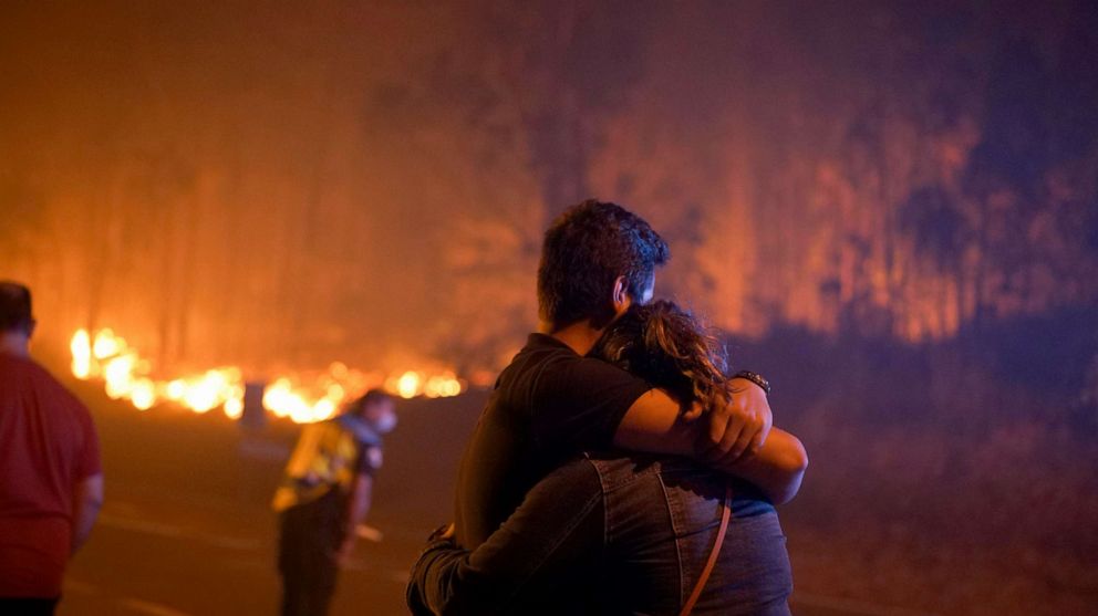 PHOTO: Two people embrace as firefighters battle wildfires, Aug. 5, 2022, in Pontevedra, Spain.