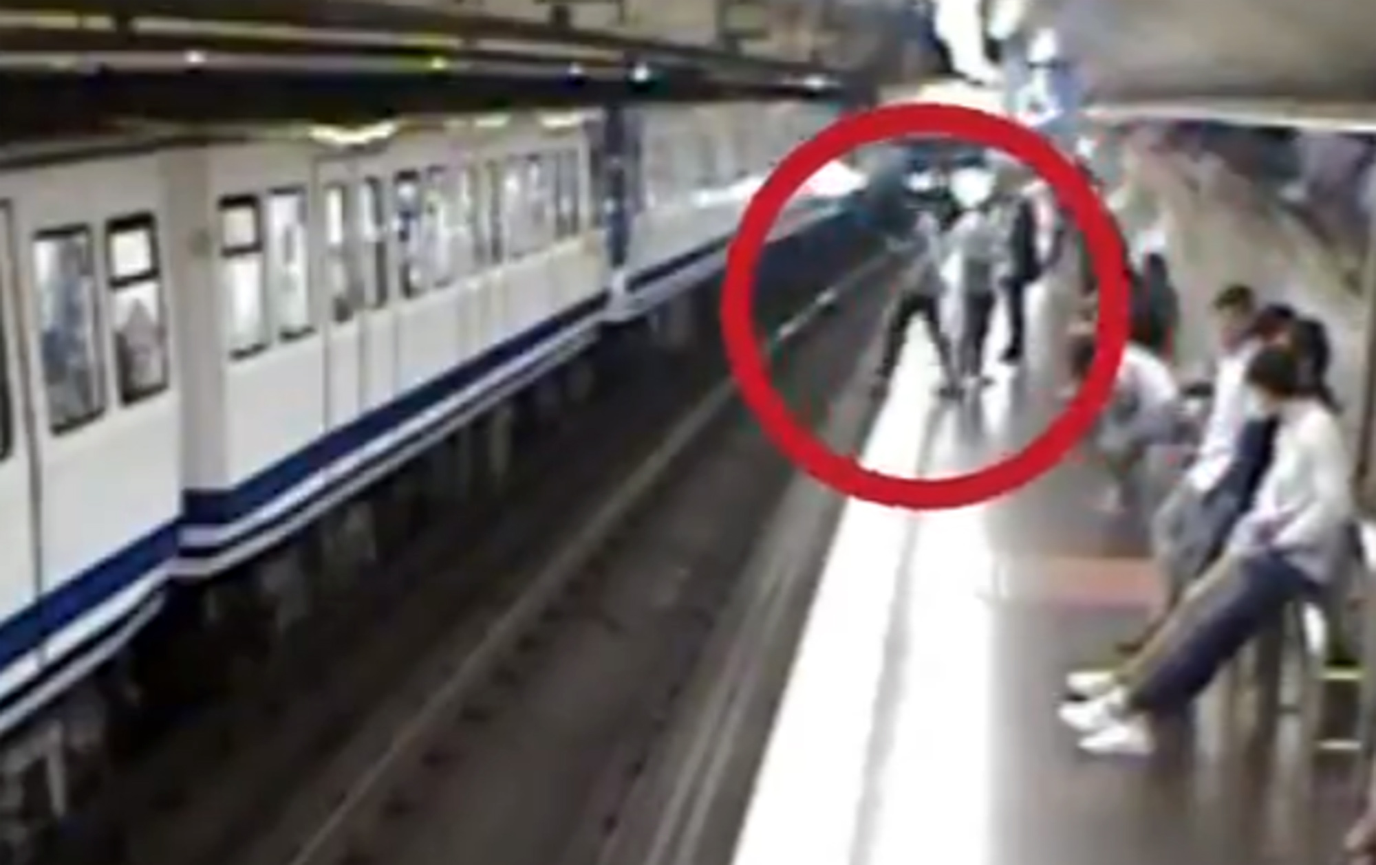 PHOTO: An image made from surveillance video released on Oct. 24, 2019, by Madrid Metro in Spain shows a woman looking at her phone as she steps off of the train platform and falls onto the track in front of an oncoming train. 