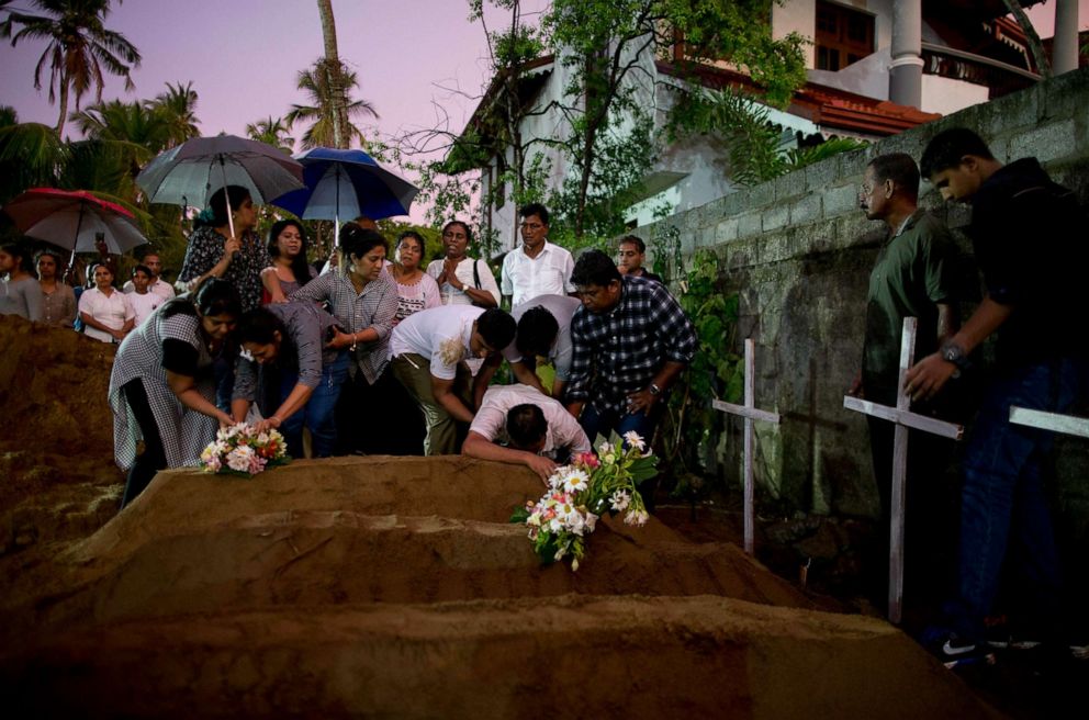 PHOTO: Relatives place flowers after the burial of three victims who died in an  Easter Sunday bomb blast at St. Sebastian Church in Negombo, Sri Lanka, April 22, 2019.